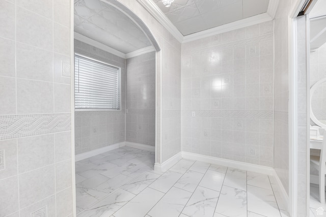 bathroom with ornamental molding, tile walls, and marble finish floor