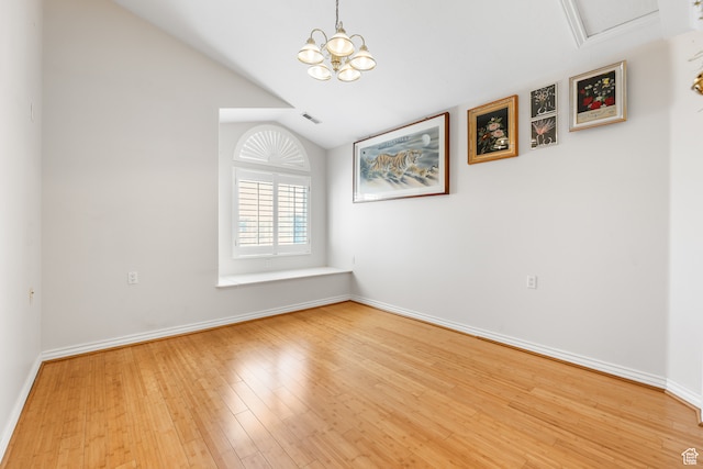 unfurnished dining area with visible vents, baseboards, vaulted ceiling, and wood finished floors