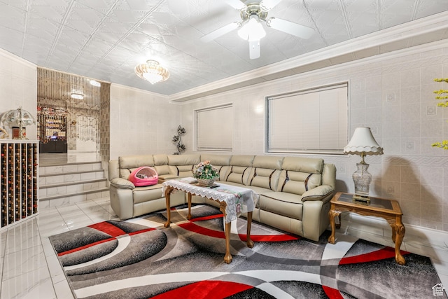 tiled living room with crown molding, ceiling fan, and tile walls