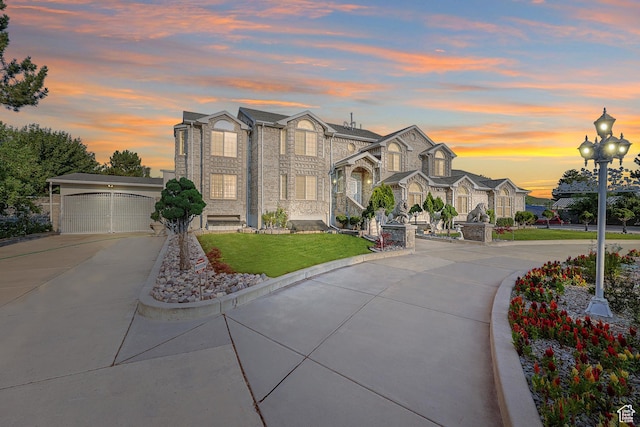 view of front of home featuring a yard, a garage, and concrete driveway