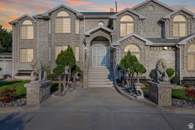 french provincial home featuring concrete driveway