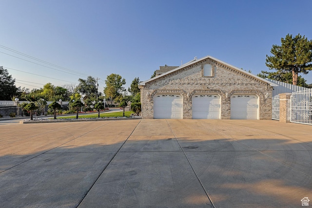view of front of house with a garage, fence, and brick siding