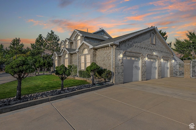 view of front of property with a yard, brick siding, a garage, and concrete driveway
