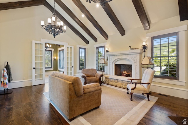 living area featuring dark wood finished floors, high vaulted ceiling, a premium fireplace, and an inviting chandelier