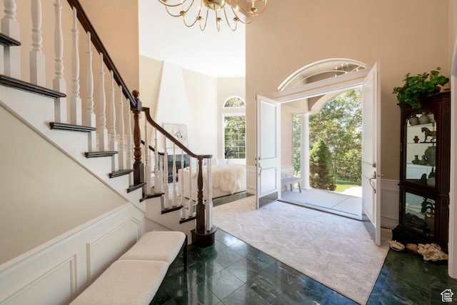 3880 E Thousand Oaks Cir, Salt Lake City, UT 84124 - foyer featuring plenty of natural light, a notable chandelier, wainscoting, and a decorative wall