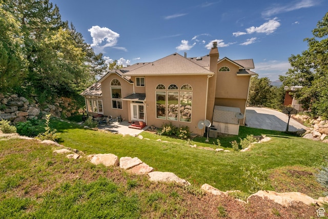 3880 E Thousand Oaks Cir, Salt Lake City, UT 84124 - back of property with stucco siding, a patio area, a lawn, and a chimney