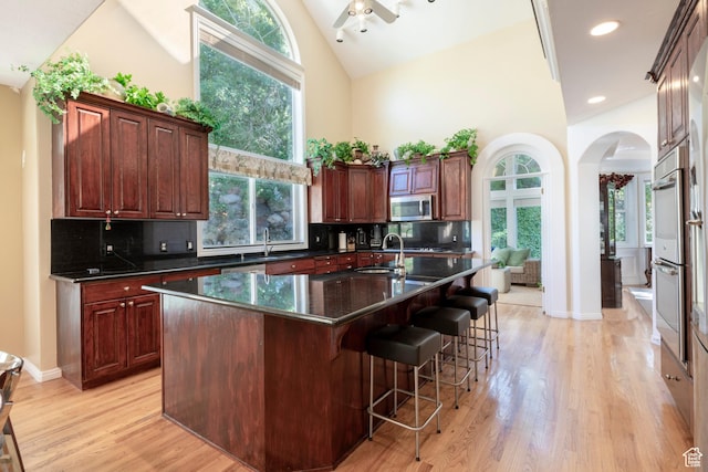 3880 E Thousand Oaks Cir, Salt Lake City, UT 84124 - kitchen featuring ceiling fan, appliances with stainless steel finishes, arched walkways, high vaulted ceiling, and a sink