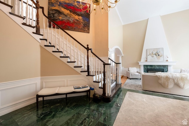 3880 E Thousand Oaks Cir, Salt Lake City, UT 84124 - stairs with a notable chandelier, marble finish floor, a high ceiling, a decorative wall, and a premium fireplace