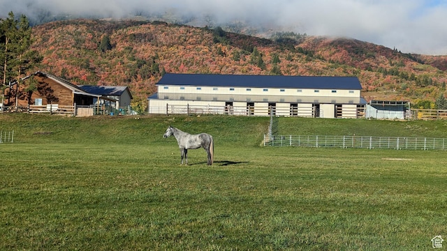 exterior space featuring a mountain view, an exterior structure, an outdoor structure, and a rural view