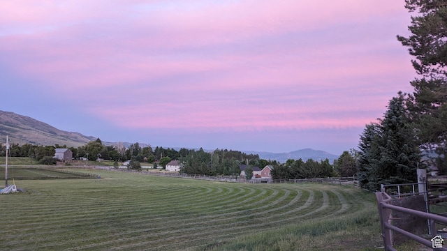 view of property's community featuring a mountain view, a lawn, and a rural view