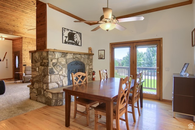 dining area featuring french doors, a fireplace, light wood-style floors, ceiling fan, and ornamental molding