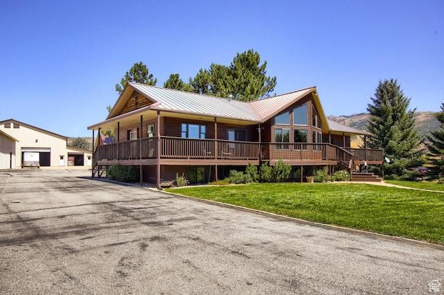 view of front facade featuring a front lawn, metal roof, a standing seam roof, and a garage