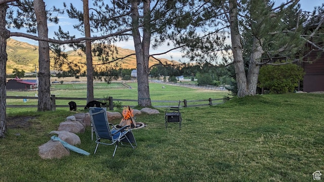 view of home's community featuring fence, a rural view, and a lawn