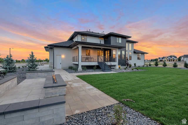 165 S Farmhouse Cir, Kaysville, UT 84037 - rear view of house with a porch, a fire pit, driveway, a lawn, and a patio area