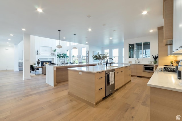 165 S Farmhouse Cir, Kaysville, UT 84037 - kitchen with a spacious island, a sink, open floor plan, modern cabinets, and a glass covered fireplace