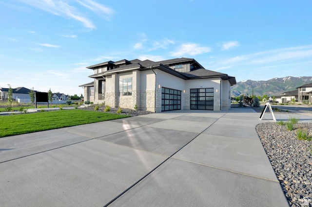 165 S Farmhouse Cir, Kaysville, UT 84037 - view of property exterior featuring concrete driveway, stone siding, an attached garage, a mountain view, and stucco siding
