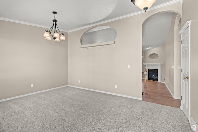 880 E 300 S, Smithfield, UT 84335 - carpeted empty room with crown molding, arched walkways, baseboards, and a glass covered fireplace