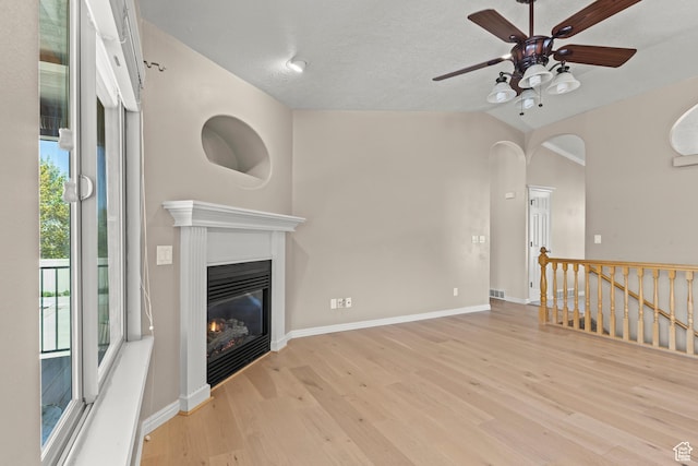 880 E 300 S, Smithfield, UT 84335 - unfurnished living room with ceiling fan, arched walkways, a glass covered fireplace, baseboards, and wood finished floors