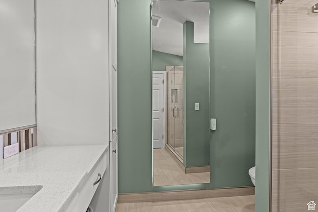 880 E 300 S, Smithfield, UT 84335 - bathroom featuring vanity, baseboards, a stall shower, and toilet