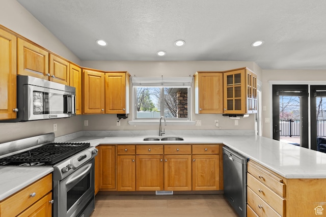 880 E 300 S, Smithfield, UT 84335 - kitchen with appliances with stainless steel finishes, a sink, light countertops, a peninsula, and light wood-style floors