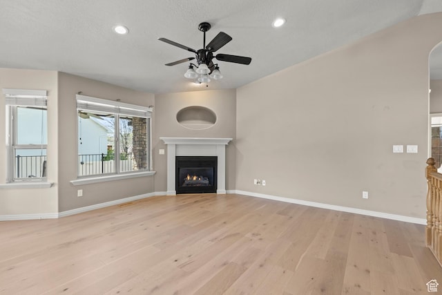 880 E 300 S, Smithfield, UT 84335 - unfurnished living room with a glass covered fireplace, baseboards, a ceiling fan, and light wood finished floors