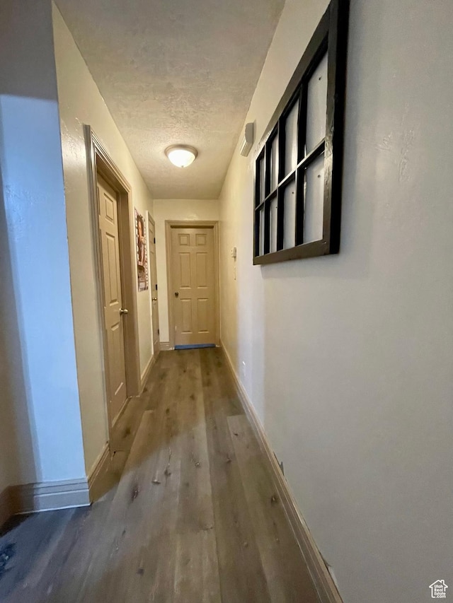 221 N 100 E, Price, UT 84501 - hallway featuring wood finished floors, baseboards, and a textured ceiling