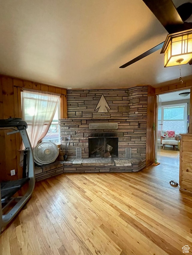 221 N 100 E, Price, UT 84501 - unfurnished living room featuring hardwood / wood-style floors, ceiling fan, and a stone fireplace