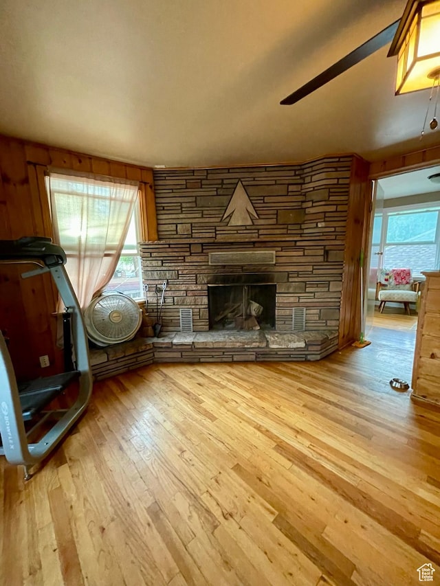 221 N 100 E, Price, UT 84501 - unfurnished living room featuring hardwood / wood-style flooring, a ceiling fan, and a stone fireplace