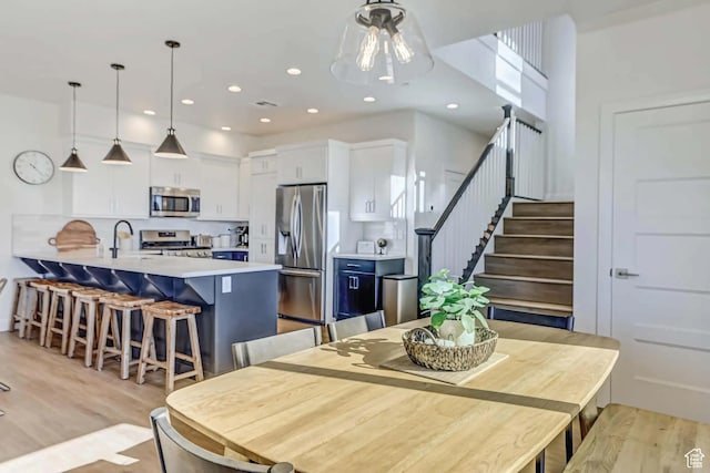 1240 E Villa Way Unit 64, Washington, UT 84780 - dining room featuring light wood finished floors, stairway, and recessed lighting