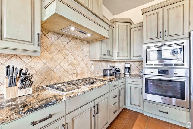 3193 S 4900 W, Hurricane, UT 84737 - kitchen featuring tile patterned flooring, stainless steel appliances, cream cabinetry, tasteful backsplash, and custom range hood