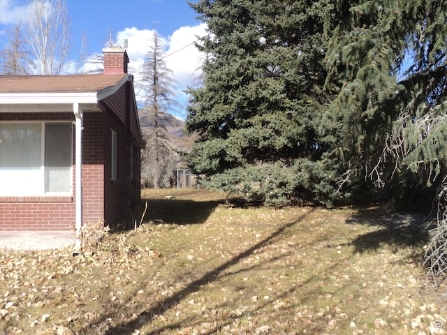 50 W 250 N, Midway, UT 84049 - view of side of home featuring brick siding, a yard, and a chimney