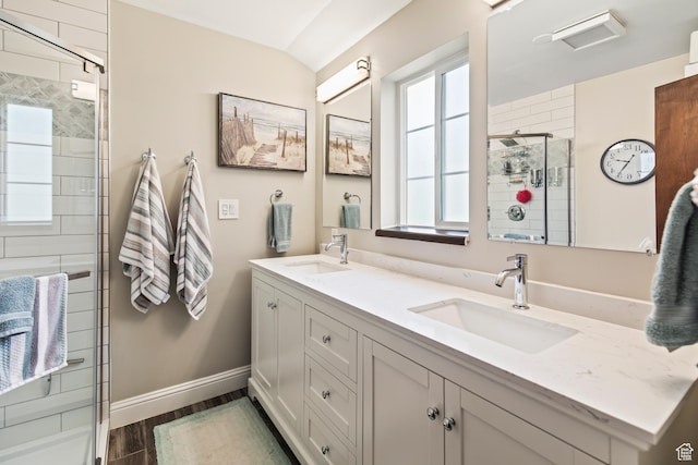 bathroom with a shower stall, wood finished floors, baseboards, and a sink