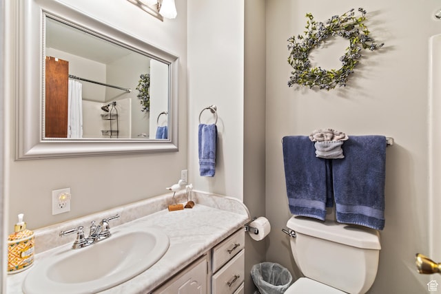 bathroom featuring vanity, curtained shower, and toilet