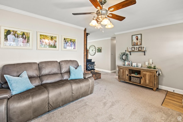 living area featuring ceiling fan, baseboards, ornamental molding, and a wood stove