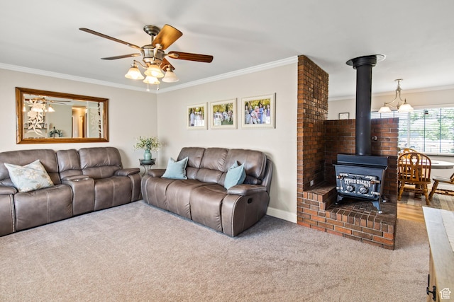 living room with crown molding, a wood stove, a ceiling fan, and carpet floors