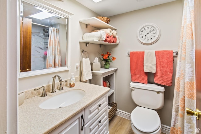 bathroom featuring vanity, a shower with shower curtain, wood finished floors, baseboards, and toilet