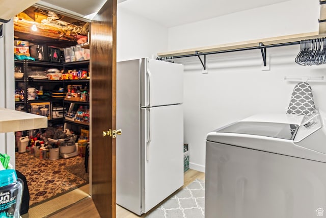 washroom featuring light wood-style floors, laundry area, and washer and clothes dryer