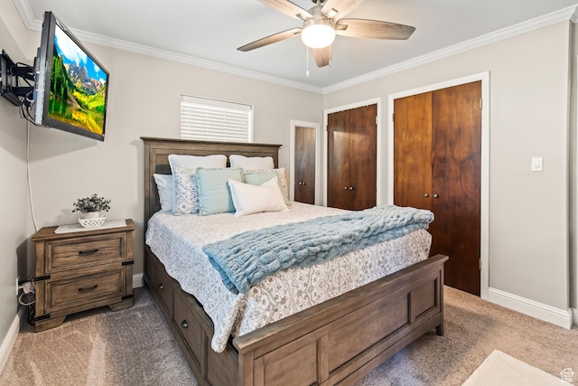 bedroom with ceiling fan, baseboards, multiple closets, ornamental molding, and carpet flooring