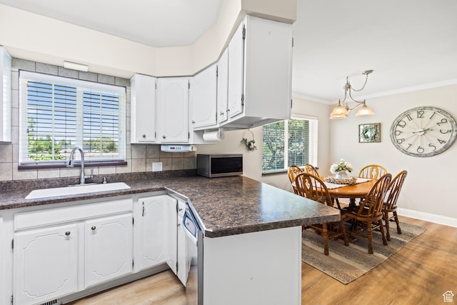kitchen featuring dark countertops, light wood-style flooring, stainless steel appliances, and a sink