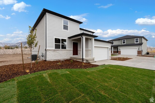 1264 N Berra Blvd Unit 133, Tooele, UT 84074 - view of front of home with fence, driveway, brick siding, and a front yard