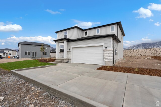 1264 N Berra Blvd Unit 133, Tooele, UT 84074 - view of front of house featuring a garage, a mountain view, and driveway
