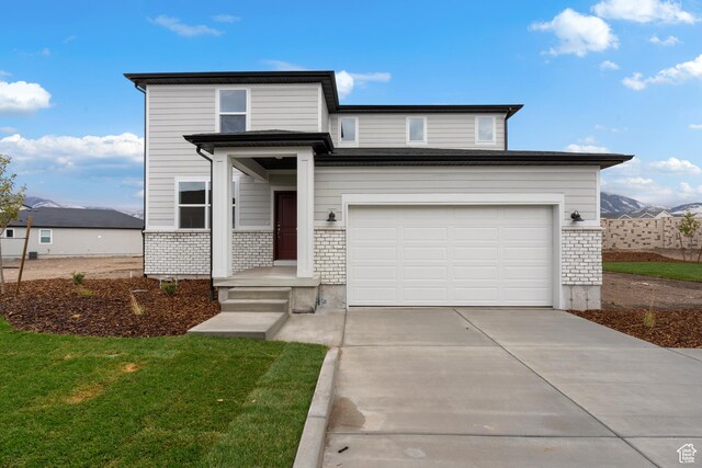 1264 N Berra Blvd Unit 133, Tooele, UT 84074 - traditional home with brick siding, an attached garage, driveway, and a front lawn