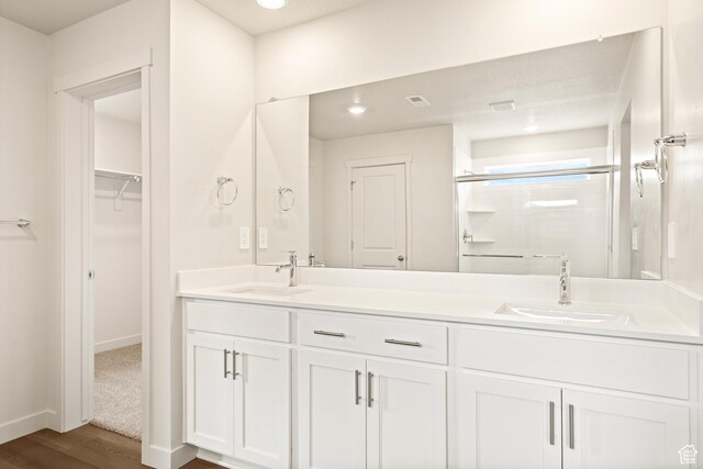 1264 N Berra Blvd Unit 133, Tooele, UT 84074 - bathroom featuring double vanity, a stall shower, a sink, and wood finished floors