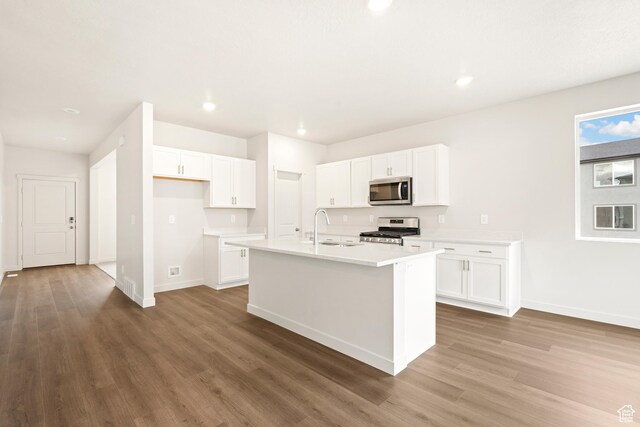 1264 N Berra Blvd Unit 133, Tooele, UT 84074 - kitchen with a sink, stainless steel appliances, baseboards, white cabinetry, and wood finished floors
