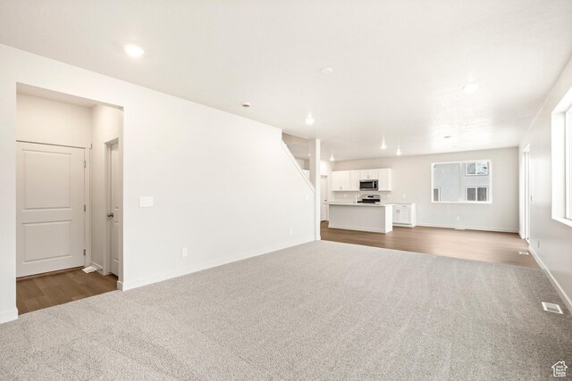 1264 N Berra Blvd Unit 133, Tooele, UT 84074 - unfurnished living room with recessed lighting, baseboards, dark carpet, and visible vents