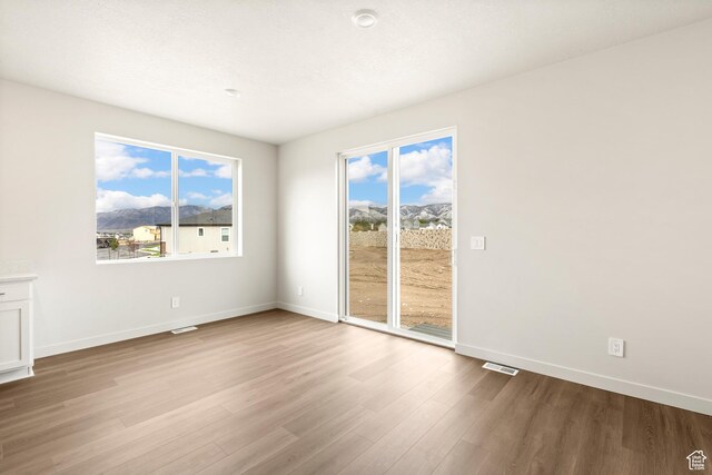 1264 N Berra Blvd Unit 133, Tooele, UT 84074 - unfurnished room featuring baseboards, visible vents, and wood finished floors