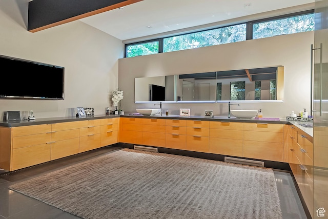 bathroom featuring a sink, a towering ceiling, and double vanity