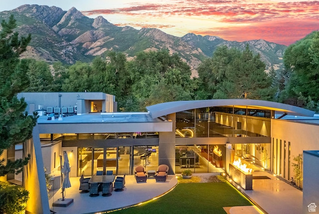 back of property at dusk with a mountain view