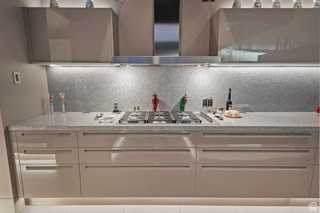 kitchen with wall chimney exhaust hood, stainless steel gas stovetop, and backsplash