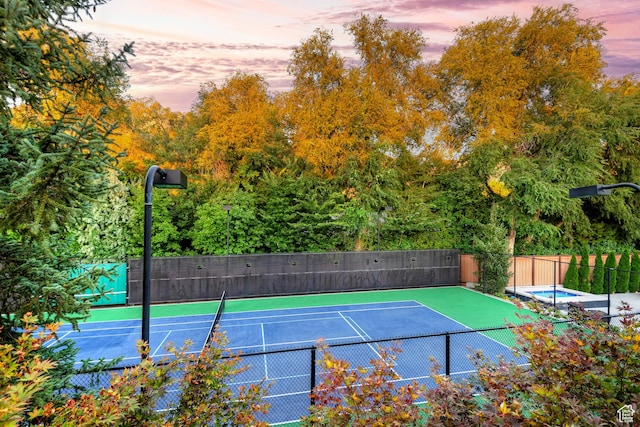 view of tennis court featuring fence